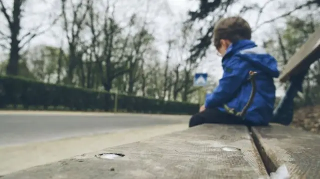 Child sat alone on bench