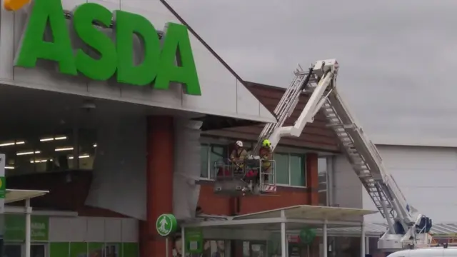 Firefighters repair the roof