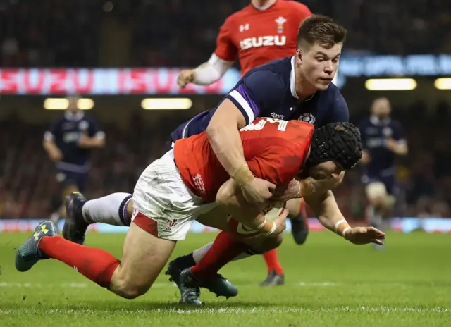 Scotland centre Huw Jones tackles Wale's Leigh Halfpenny