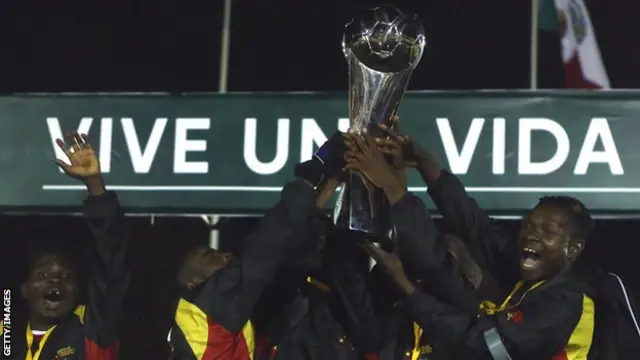 The Angola team cheer and lift their trophy