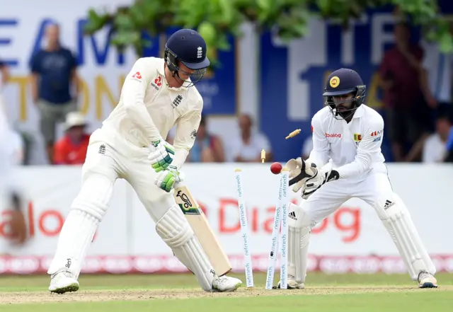 England's Keaton Jennings (L) is bowled out by Sri Lankan's Dilruwan Perera