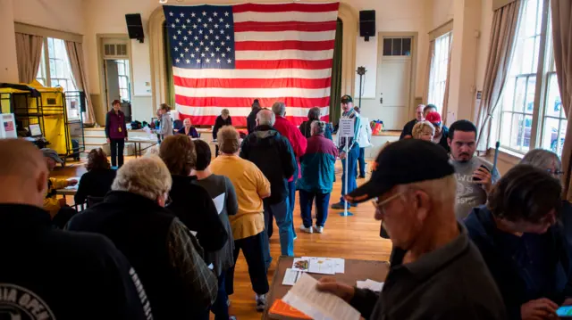 Voters wait to get a ballot at a polling station during the mid-term elections at the Old Stone School in Hillsboro, Virginia