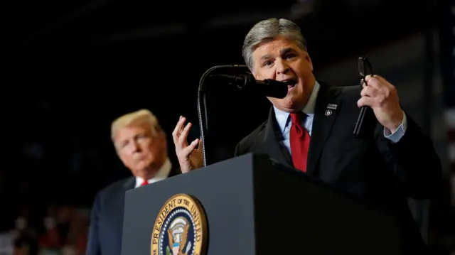 U.S. President Donald Trump listens as Sean Hannity from Fox News speaks at a campaign rally on the eve of the U.S. mid-term elections at the Show Me Center in Cape Girardeau, Missouri, U.S., November 5, 2018.