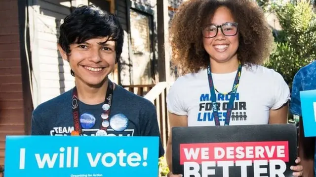 Two people from the March for our Lives movement hold placards pledging to vote in this file photo