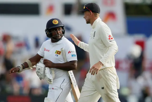 England"s captain Joe Root (R) shares a moment with Sri Lanka"s Rangana Herath