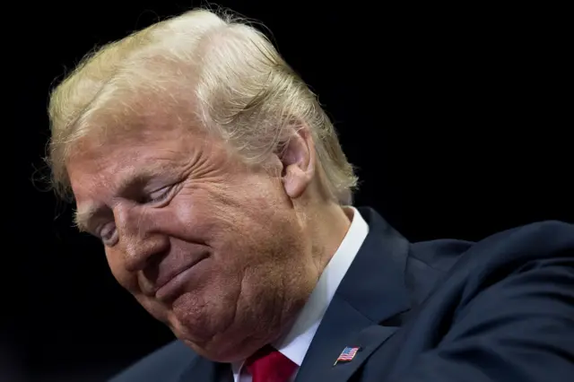 Trump smiles while looking down at a rally earlier this week