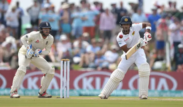 England keeper Ben Foakes looks on as Sri Lanka batsman Dinesh Chandimal drives