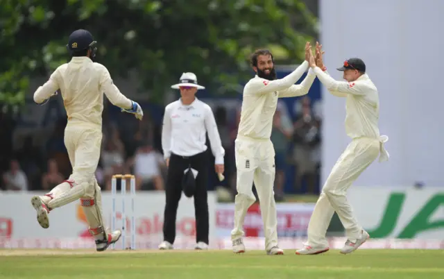 England bowler Moeen Ali is congratulated by captain Joe Root after bowling Sri Lanka batsman Dhananjaya de Silva