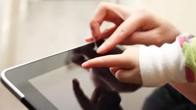 Child points at tablet screen