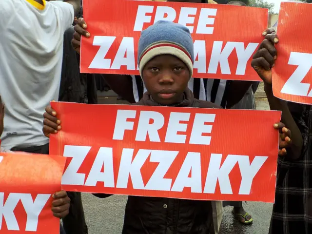 A boy holds a large sign reading "Free Zakzaky" at a protest in Nigeria in 2016.