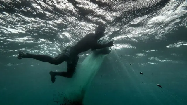 A Malagasy fisherman gathers his net.