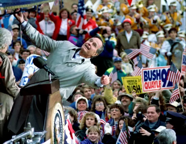 George HW Bush Bush looks back over the top of the train he is travelling on at supporters in Wisconsin. Photo: October 1992