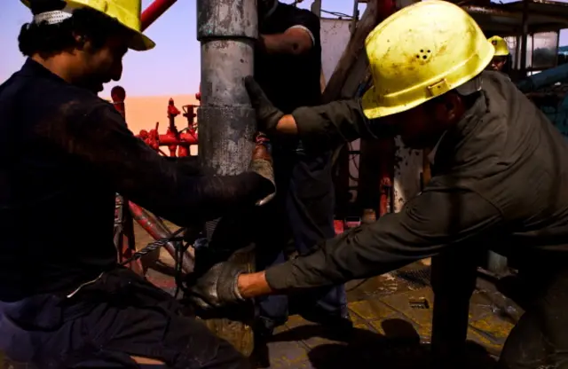 Men work at an oil-drilling rig in El Sharara.