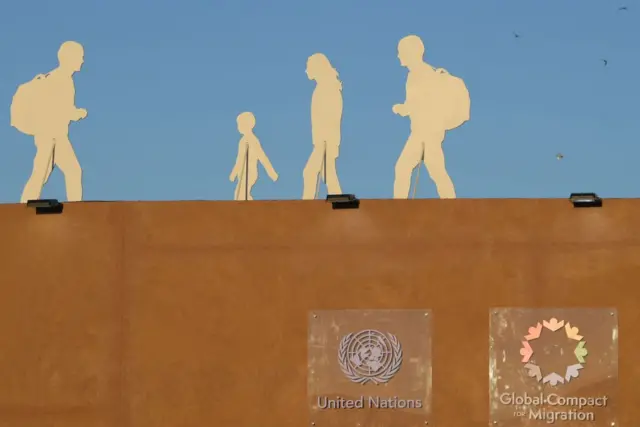 A picture taken on 10 December 2018 shows silhouettes of migrants installed at the grounds of the conference in the Moroccan city of Marrakesh.