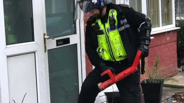 Police officer about to enter a property