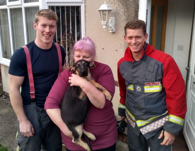 Two firemen, a dog and her owner