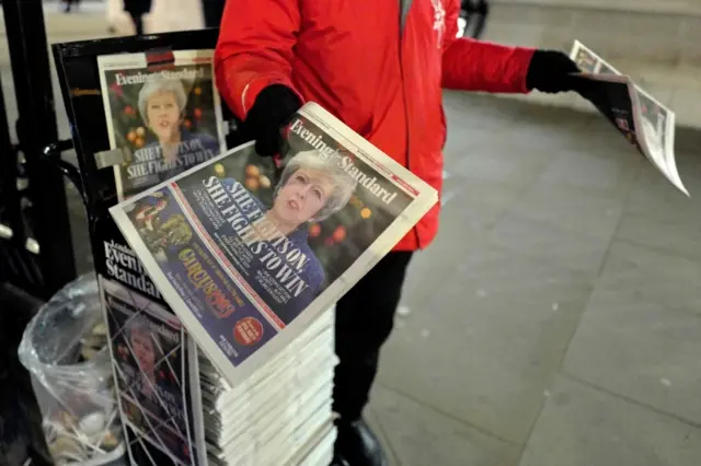 Vendor handing out Evening Standard newspaper