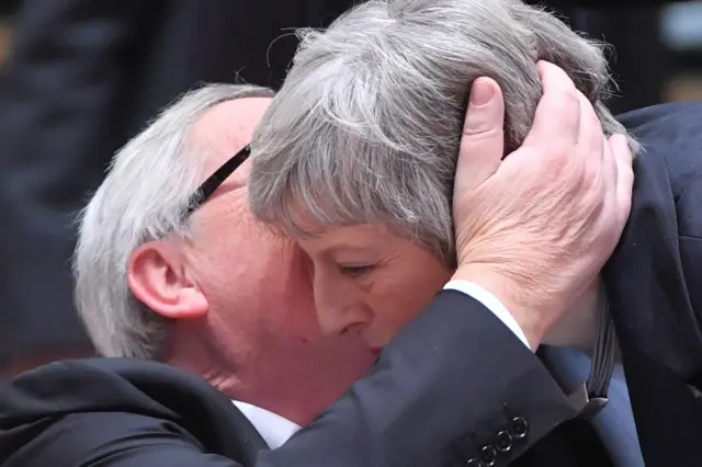 President of the European Commission Jean-Claude Juncker whispers in Theresa May's ear