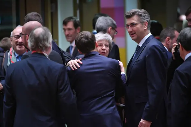 Theresa May hugs French President Emmanuel Macron