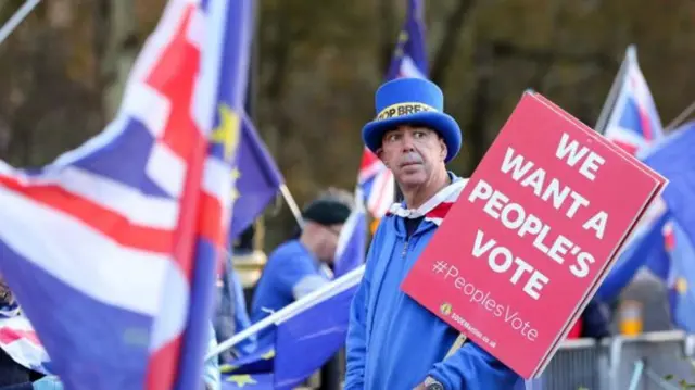 A man holding a poster calling for another vote