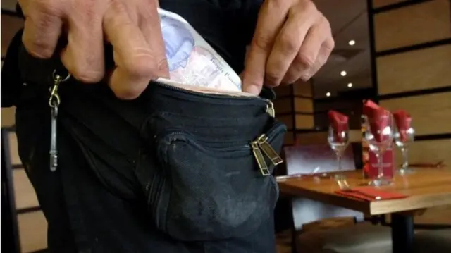 someone putting money in pocket