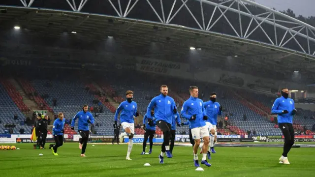 Huddersfield players warm up in the rain