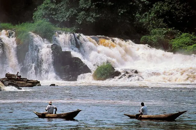 People on canoes pictured in front of the Lobé River waterfalls in Cameroon.