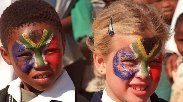 Children with painting of South African flad on their faces