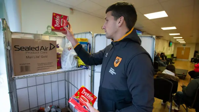 A Hull City player sorting through donations