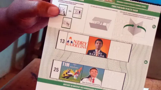 Someone holds up a ballot paper showing the two presidential candidates in Madagascar