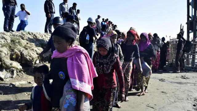 Myanmar Navy personnel escorting a group of Rohingya Muslims back to their camp in Sittwe