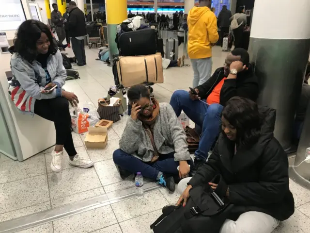 Tayo Abraham (centre) surrounded friends at Gatwick