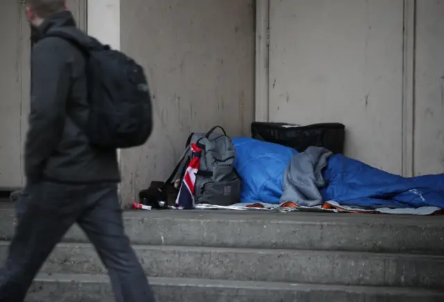 A person sleeping rough in a doorway