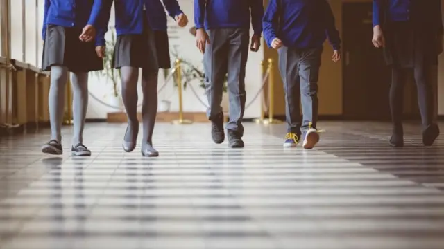 Cropped image of school kids in uniform walking together in a row