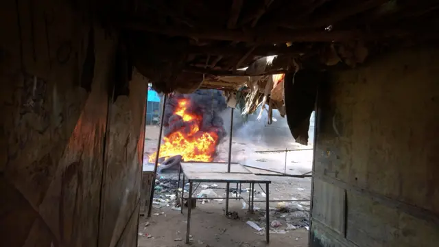 A bonfire is lit along the street during protests against price rises in Atbara, Nile River state.