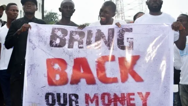 Liberians hold a banner during a demonstration over the disappearance of newly printed bills, in the capital Monrovia - September 2018