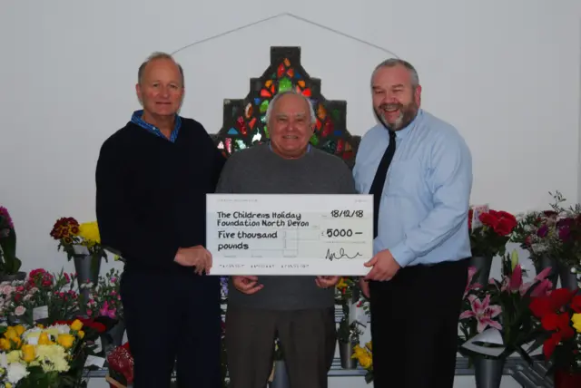 three men with a cheque