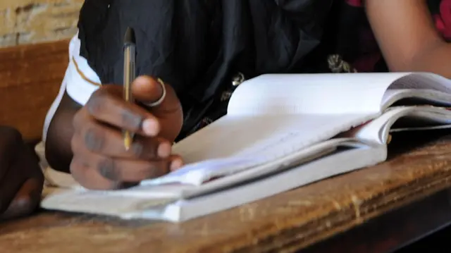 A pupil writes in her textbook