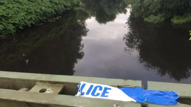 Police tape above a canal