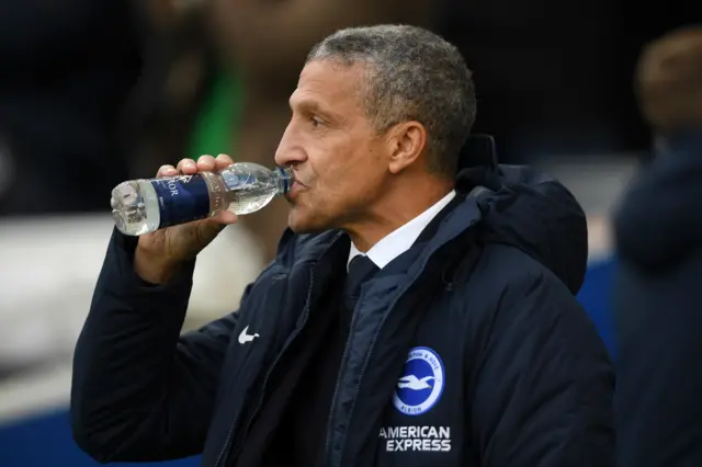 Brighton manager Chris Hughton drinks from a water bottle