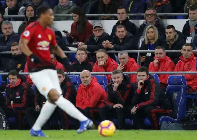 Manchester United's coaching staff watch as Anthony Martial plays the ball