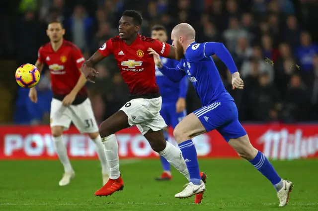 Paul Pogba competes with Aron Gunnarsson