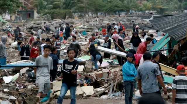 Rescuers and residents look for survivors along the coast in South Lampung