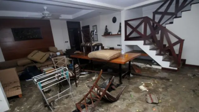 Debris and furniture are seen strewn in the damaged interior of a home in Carita