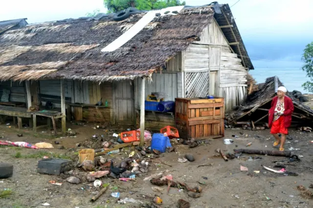 A local resident walks near her damaged house hit by tsunami at Tanjung Lesung district in Pandeglang, Banten province, Indonesia. Photo: 23 December 2018