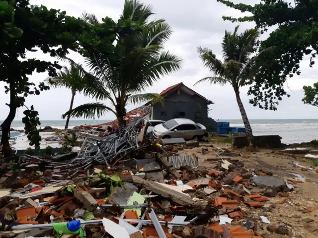 A car is seen among ruins after the tsunami hit Carita