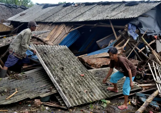 Residents collect debris from their collapsed house after it was hit by a tsunami at Panimbang district in Pandeglang