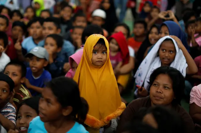 Children gather to receive occupational therapy at a camp for displaced victims of the earthquake and tsunami in Palu,