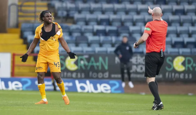 Livingston striker Dolly Menga protests about his torn shirt