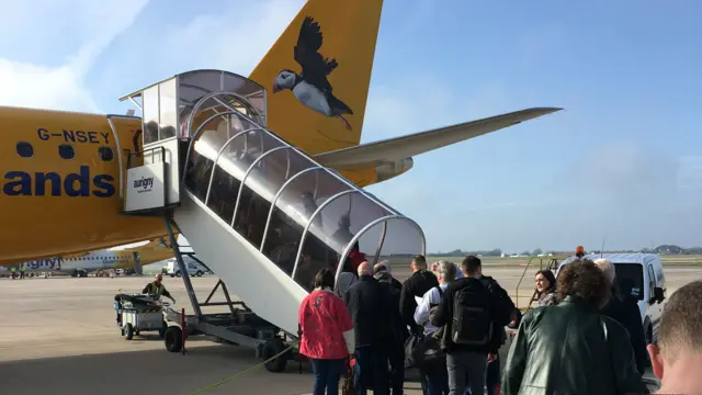 Passengers board an Aurigny plane